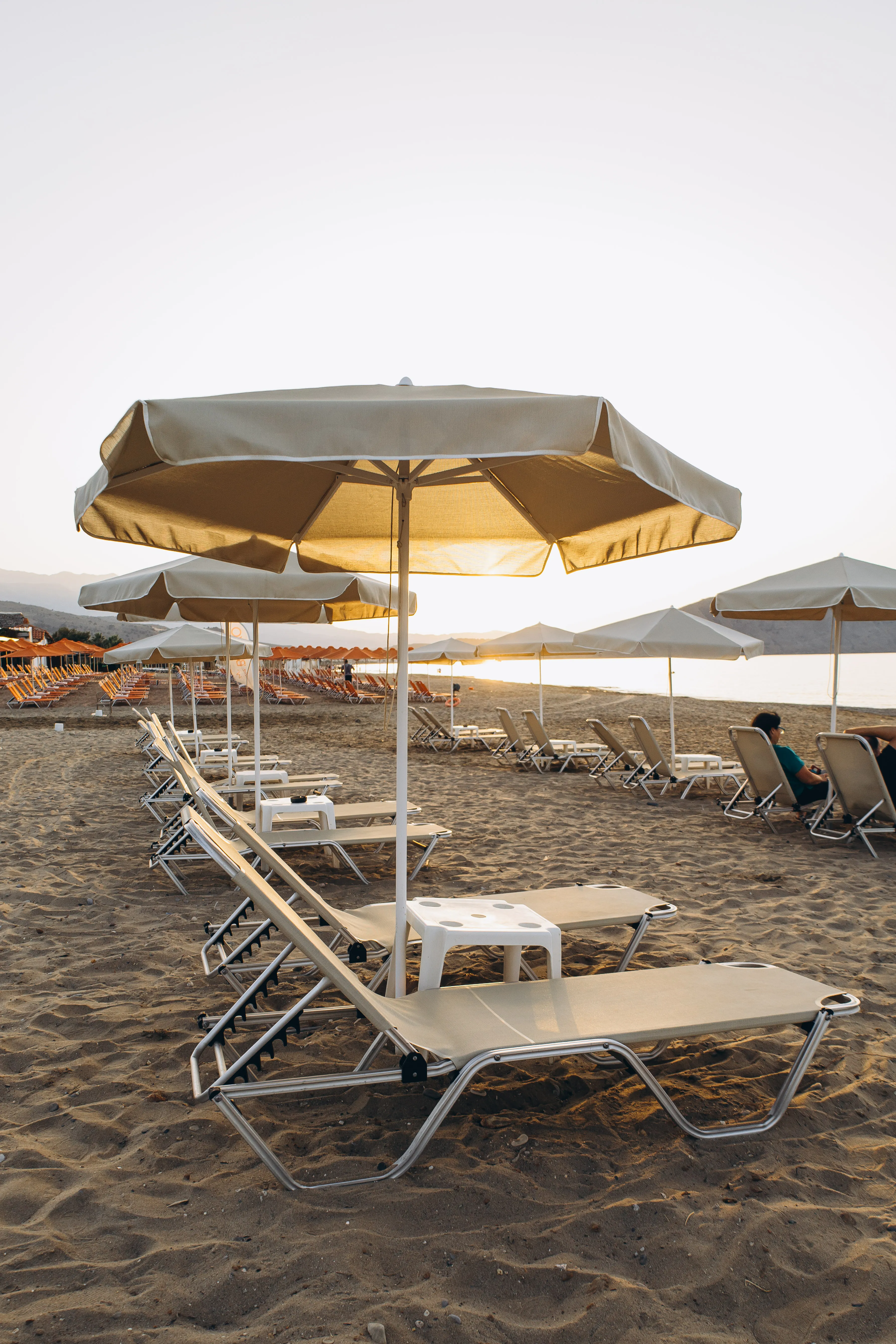 Sonnenschirme in Reihe am Kournas Beach im Morgenlicht